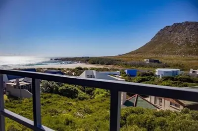 a view of the beach from the balcony of a house at The Red Door in Pringle Bay