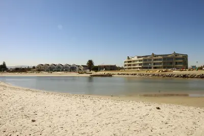 a beach with a building in the background and a building at Westward HO Apartment 13 in Cape Town