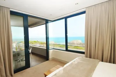 a bedroom with a bed and a view of the ocean at bamboo @ Le Paradis in Hermanus