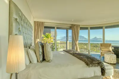 a bedroom with a large bed with a view of the ocean at Atlantic Palms in Cape Town
