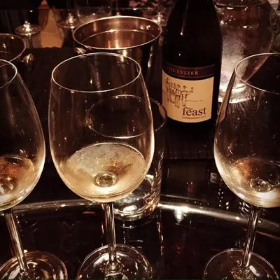 a group of wine glasses on a counter with a bottle of wine at Domaine Coutelier in Stellenbosch