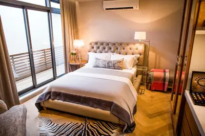 a bedroom with a large bed with a large window at Nicara to Akker Collective in Stellenbosch