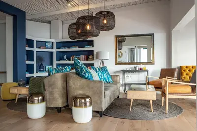 a living room with a couch and chairs and a mirror at Villa Marine Guest House in Pringle Bay