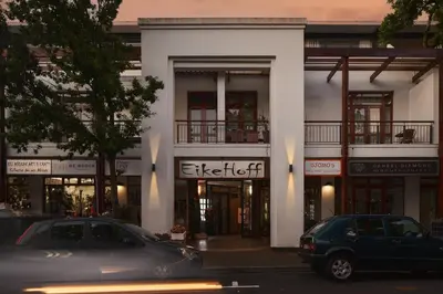 a white building with cars parked in front of it at 22 Eikehoff Apartment in Stellenbosch