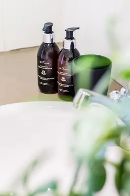 two bottles of soap sitting next to a sink at Skyview Manor in Stellenbosch