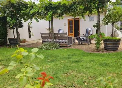 a garden with two benches and a table and chairs at Rawsonville House in Rawsonville