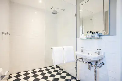 a white bathroom with a sink and a mirror at Bliss Boutique Hotel in Cape Town