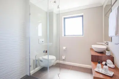 a bathroom with a toilet and a glass shower at Bliss Boutique Hotel in Cape Town