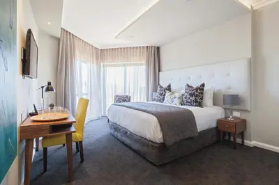 a hotel room with a bed and a desk and a window at Bliss Boutique Hotel in Cape Town