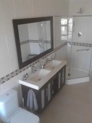 a bathroom with a sink and a toilet and a mirror at Port House in Bloubergstrand