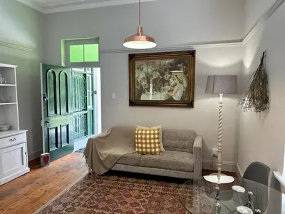 a living room with a couch and a painting on the wall at Le Manse in Franschhoek