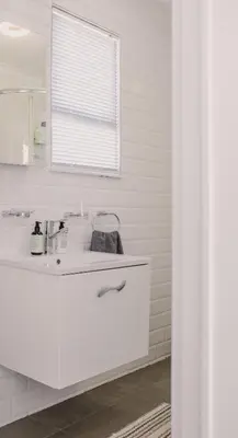 a white bathroom with a sink and a mirror at Brookwood Cottage in Somerset West