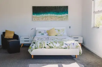 a bedroom with a bed and a painting on the wall at Brookwood Cottage in Somerset West