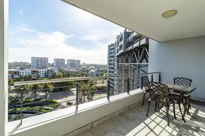 a balcony with a table and chairs on a building at Citystay Apartments Century City in Cape Town