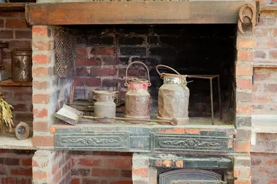 a brick fireplace with three copper pots on it at Modderkloof Farm Accommodation in Paarl