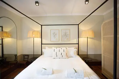 a bedroom with a large white bed with two lamps at Beckhuis in Worcester
