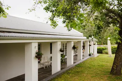 a building with white columns and a yard at Marshden Estate in Stellenbosch