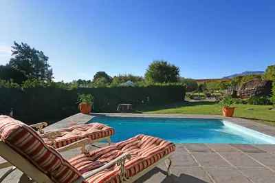 a pair of lawn chairs and a swimming pool at Marshden Estate in Stellenbosch