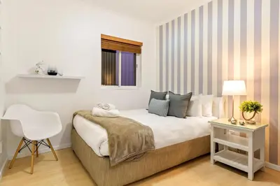 a bedroom with a bed and a chair and a window at Horizon Bay 103 in Bloubergstrand