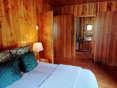 a bedroom with a bed and wooden walls at The River Siding in Wolseley