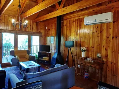 a living room with wood paneled walls and a living room with couches at The River Siding in Wolseley