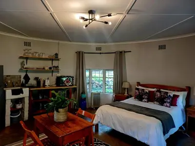a bedroom with a bed and a table and a ceiling at The River Siding in Wolseley