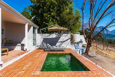 a swimming pool in the backyard of a house at La Petite Ferme in Franschhoek
