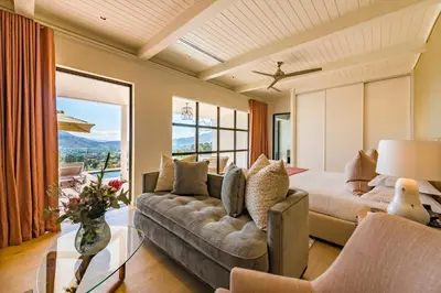 a living room with a couch and a bed at La Petite Ferme in Franschhoek