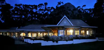 a house lit up at night with lights at La Petite Ferme in Franschhoek