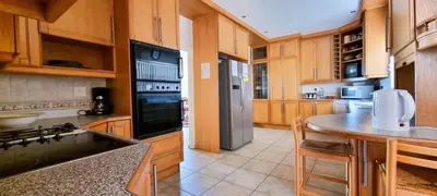 a kitchen with wooden cabinets and a counter top at Kleinmond Panorama Holidays in Kleinmond