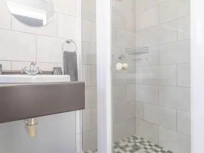 a bathroom with a sink and a shower at House on Westcliff in Hermanus