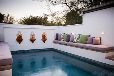 a swimming pool in a backyard with a couch next to it at Akademie Street Boutique Hotel in Franschhoek
