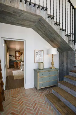 a hallway with stairs and a blue dresser and a lamp at Akademie Street Boutique Hotel in Franschhoek