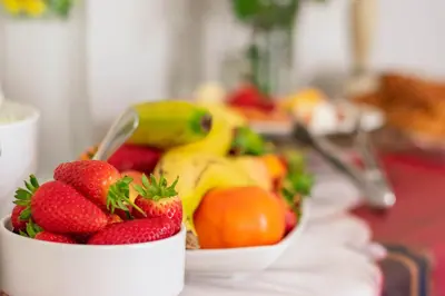 a bowl of strawberries and bananas on a table at Rozenburg Guest House in Stellenbosch