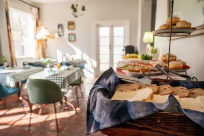 a room with a table with bread and pastries at Rozenburg Guest House in Stellenbosch