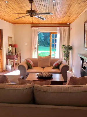 a living room with a couch and a table at Oak Tree Lodge in Paarl