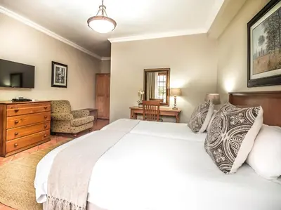 a bedroom with a large white bed and a couch at Oak Tree Lodge in Paarl