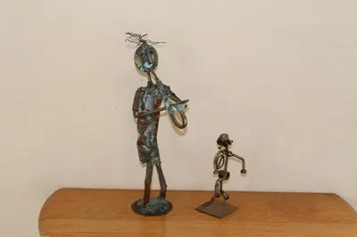 a metal statue of a man holding a bicycle at On The Cliff Guest House in Hermanus