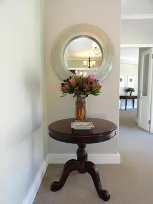 a vase of flowers on a table in a hallway at Sugarbird Manor in Stellenbosch