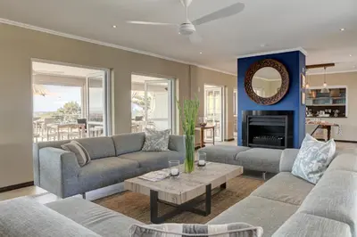 a living room with two couches and a fireplace at Abalone Guest Lodge in Hermanus