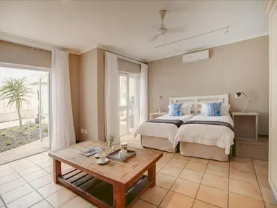 a bedroom with a large bed and a table at Abalone Guest Lodge in Hermanus