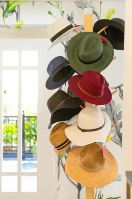 a bunch of hats hanging on a wall at Protea Hotel by Marriott Franschhoek in Franschhoek