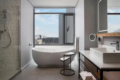 a bathroom with a tub and a sink and a window at Cape Town Marriott Hotel Crystal Towers in Cape Town
