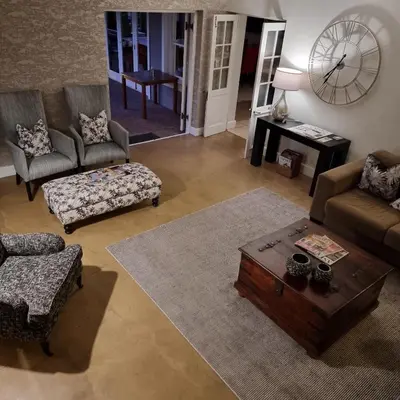 a living room with a couch and a coffee table at Plumwood Boutique Hotel by The Living Journey Collection in Franschhoek