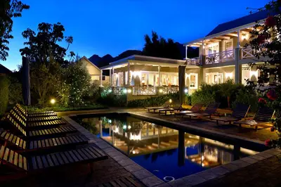 a house with a swimming pool at night at Plumwood Boutique Hotel by The Living Journey Collection in Franschhoek