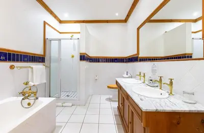 a bathroom with two sinks and a shower at Evergreen Manor and Spa in Stellenbosch