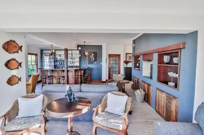 a living room with a couch and a table and chairs at Lavender Manor Guest Lodge in Hermanus