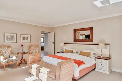 a bedroom with a large bed and a mirror at Lavender Manor Guest Lodge in Hermanus