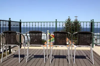 a group of chairs sitting on a deck overlooking the ocean at Lavender Manor Guest Lodge in Hermanus