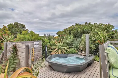 a bath tub sitting on top of a wooden deck at Stay At Friends in Bettyʼs Bay